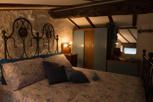 a bedroom with a large bed with a metal headboard at La Casa del Comandante in Sulzano
