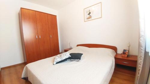 sypialnia z łóżkiem i drewnianą szafką w obiekcie Apartment Matika, terrace apartment 10 minutes walk from center w Rovinj