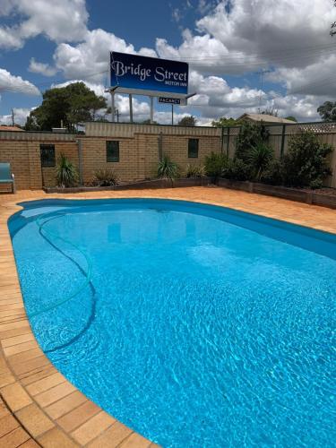 a large blue swimming pool in front of a building at Bridge Street Motor Inn in Toowoomba