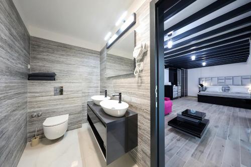a bathroom with two sinks and a bed in the background at Boutique Residence Cosmopolis in Bibinje