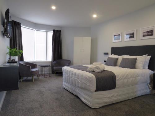 a bedroom with a large white bed and a desk at The Studio Akaroa in Akaroa