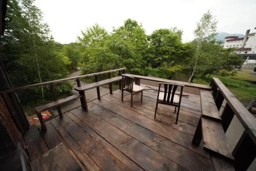 a deck with two benches and a table and chairs at ARtINn 極寒藝術伝染装置 in Teshikaga