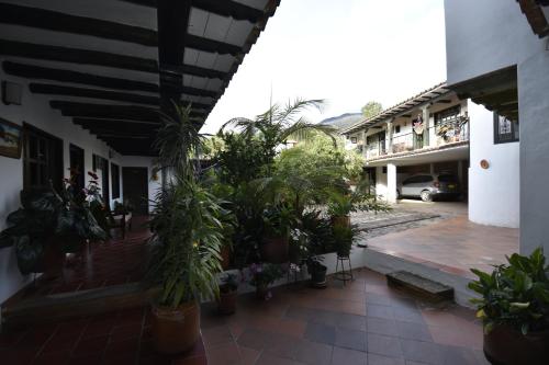 a courtyard with potted plants in a building at Hospederia La Fuente in Villa de Leyva