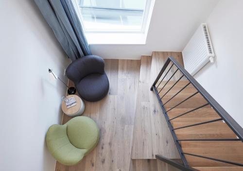 a living room with a staircase and a green chair at Faktorei in Innsbruck