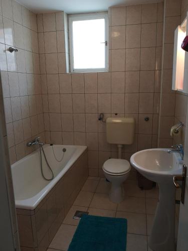 a bathroom with a tub and a toilet and a sink at David in 5 in Primošten