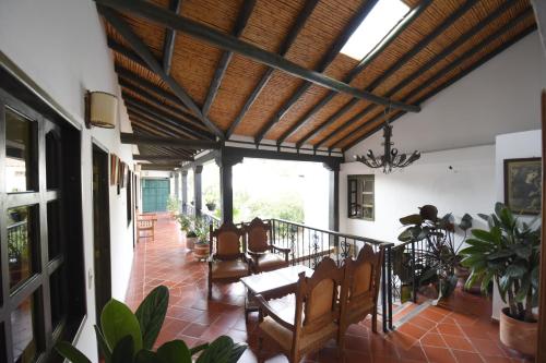 a living room with a wooden ceiling and a table and chairs at Hospederia La Fuente in Villa de Leyva