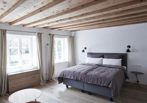 a bedroom with a large bed and two windows at Faktorei in Innsbruck