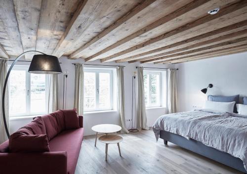 1 dormitorio con cama, sofá y ventanas en Faktorei en Innsbruck