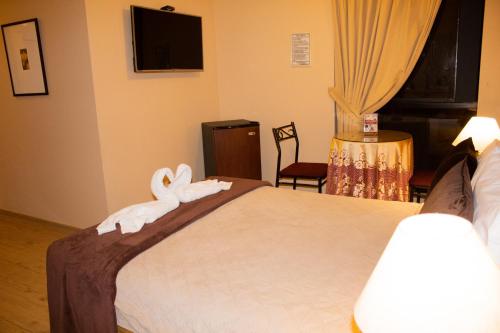 a hotel room with a bed with towel animals on it at Solis Dies Hotel in Lima