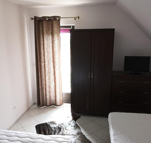 a bedroom with a bed and a dresser and a window at Villa Watamu in Trzęsacz