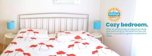 ein Schlafzimmer mit einem Bett mit roten Blumen darauf in der Unterkunft Gospoja Park & Beach Apartment Vrbnik in Vrbnik