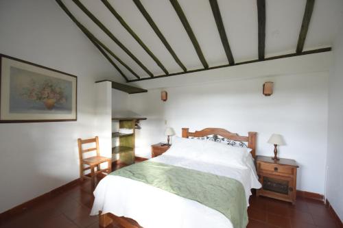 a bedroom with a large white bed in a room at Hospederia La Fuente in Villa de Leyva