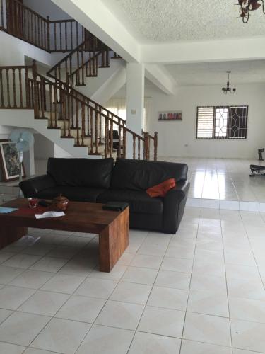 a living room with a couch and a coffee table at Suite Georgiana - Ensuite Double Bedroom, Cardiff Hall, Runaway Bay, One Mile to Beaches, 1 Hour From Montego Bay Airport in Runaway Bay