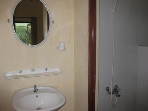 a bathroom with a sink and a mirror and a shower at Cocosand Hotel in Mui Ne