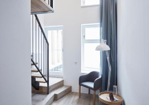 a living room with a chair and a stair case at Faktorei in Innsbruck