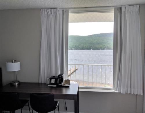 a desk with a window with a view of a lake at Lakefront Terrace Resort in Lake George