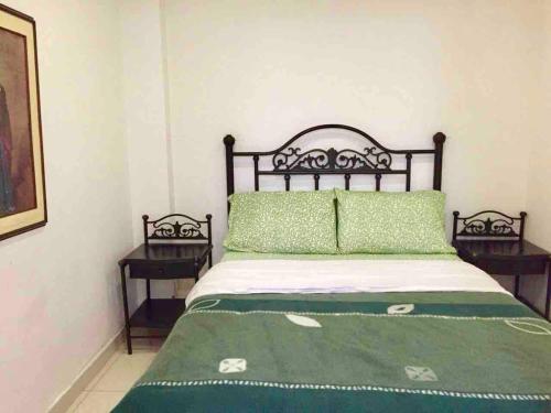 1 dormitorio con 1 cama con sábanas verdes y 2 mesas en SPACIOUS 2 BEDROOM APARTMENT CENTRAL LOCATION 101, en Bogotá