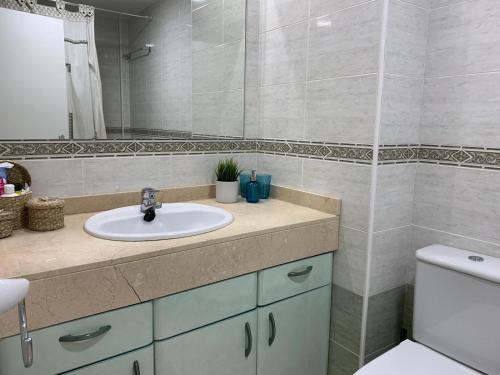 uma casa de banho com um lavatório, um WC e um espelho. em La azotea em Cambrils
