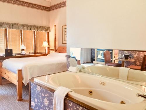 a hotel room with a tub and a bed at Afton House Inn in Afton