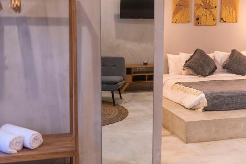 um quarto com uma cama, uma cadeira e um espelho em Canggu Dream Studios & Villas em Canggu