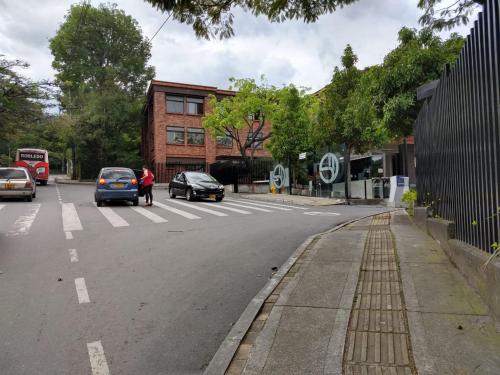 una calle con coches estacionados al costado de la carretera en Apartamento completo medellin, en Medellín