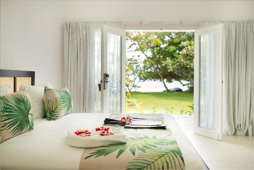 a bedroom with a large bed with flowers on it at Lomani Island Resort &ndash; Adults Only in Malolo Lailai