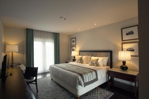 a hotel room with a large bed and a window at The Shalimar Boutique Hotel in Malang