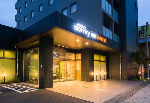 a building with a sign on the front of it at Dormy Inn Express Kakegawa in Kakegawa