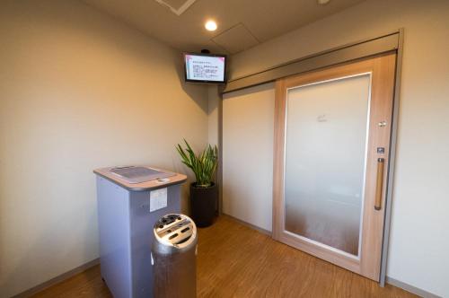an empty hallway with a door and a trash can at Dormy Inn Express Kakegawa in Kakegawa