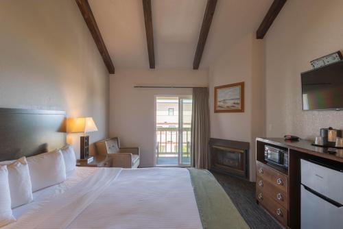 een hotelkamer met een groot bed en een televisie bij Cannery Row Inn in Monterey