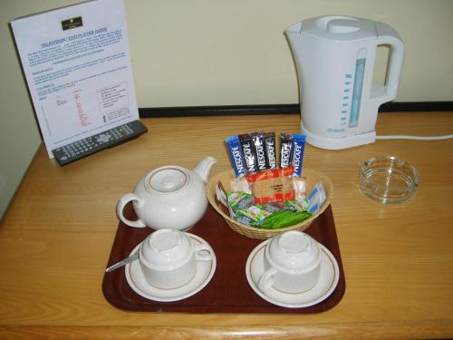 a tray with a tea pot and cups on a table at Redwings Lodge Baldock in Baldock