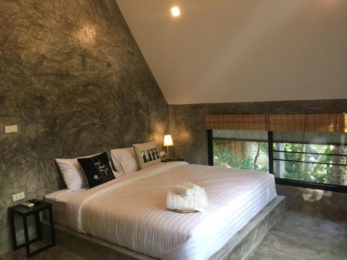 1 dormitorio con cama grande y ventana grande en Baan Rai Me Rak Organic Farmstay, en Ban Pa Khlok