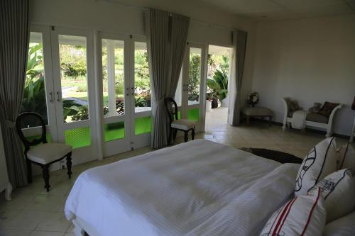 a bedroom with a bed and sliding glass doors at Pondok Plantation Luxury Mountain Escape Bedugul in Bedugul