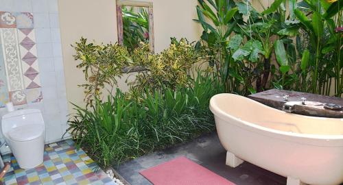 a bathroom with a bath tub and a toilet at Villa with private pool at Villa Nirvana Ubud in Ubud