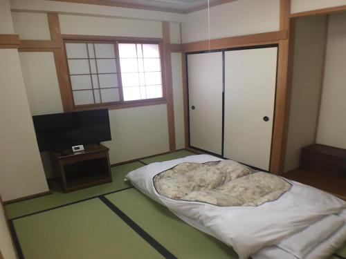 a bedroom with a bed and a flat screen tv at Hotel Nasu Otawara Hills in Otawara