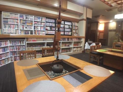 a library with a fire pit in the middle of a table at Hotel Nasu Otawara Hills in Otawara