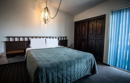 a bedroom with a bed and a chandelier at Hotel Suites Malena in Ensenada