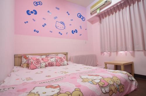 um quarto com uma cama com almofadas Hello Kitty em Love Fengchia em Taichung