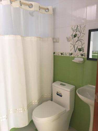 a bathroom with a white toilet and a sink at LA CASA BLANCA in Lunahuaná
