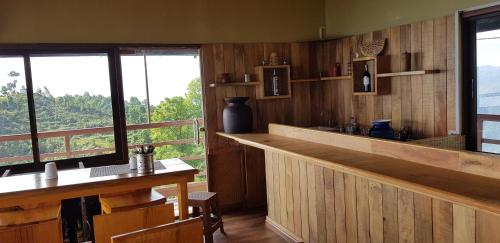a kitchen with a bar with a view of a mountain at Pumdikot Mountain Lodge in Kāskī