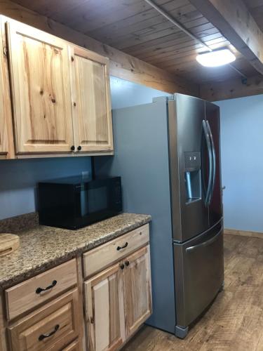 a kitchen with a refrigerator and wooden cabinets at Drift Lodge in Island Park