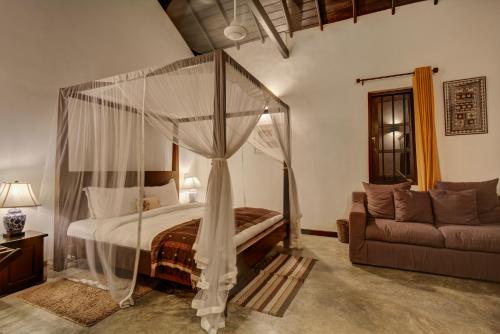 a bedroom with a canopy bed and a couch at Villa Republic Bandarawela (04 bedroom) in Bandarawela