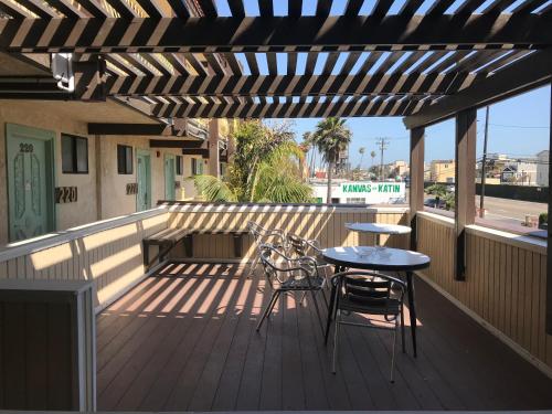 a patio with a table and chairs on a deck at 777 Motor Inn in Huntington Beach