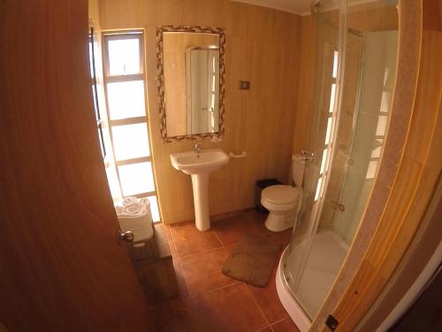 a bathroom with a toilet and a sink and a shower at Casa Ckelar Atacama in San Pedro de Atacama
