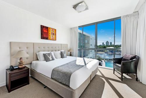 - une chambre avec un grand lit et une grande fenêtre dans l'établissement ULTIQA Freshwater Point Resort, à Gold Coast