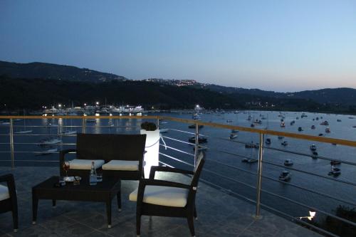 a balcony with chairs and a view of a harbor at Hotel Plaza in Porto Azzurro