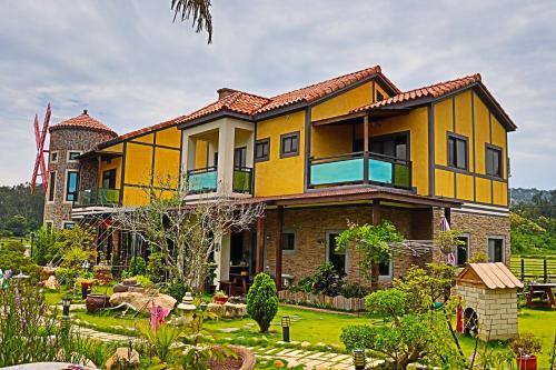 a yellow house with a garden in front of it at Wang Lao Ye B&B in Jinhu