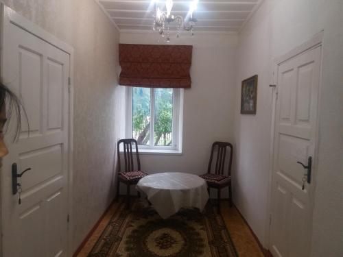 una stanza con due sedie e un tavolo e una finestra di Macedon Guest House a Barskoon