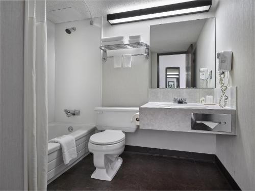 ein Badezimmer mit einem WC, einem Waschbecken und einem Spiegel in der Unterkunft Crestwood Hotel in Hinton