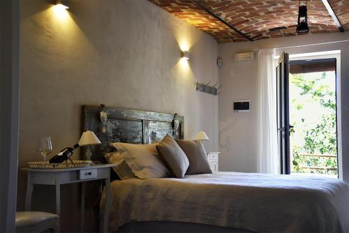 a bedroom with a bed and a table and a window at La Crusetta in San Marzano Oliveto